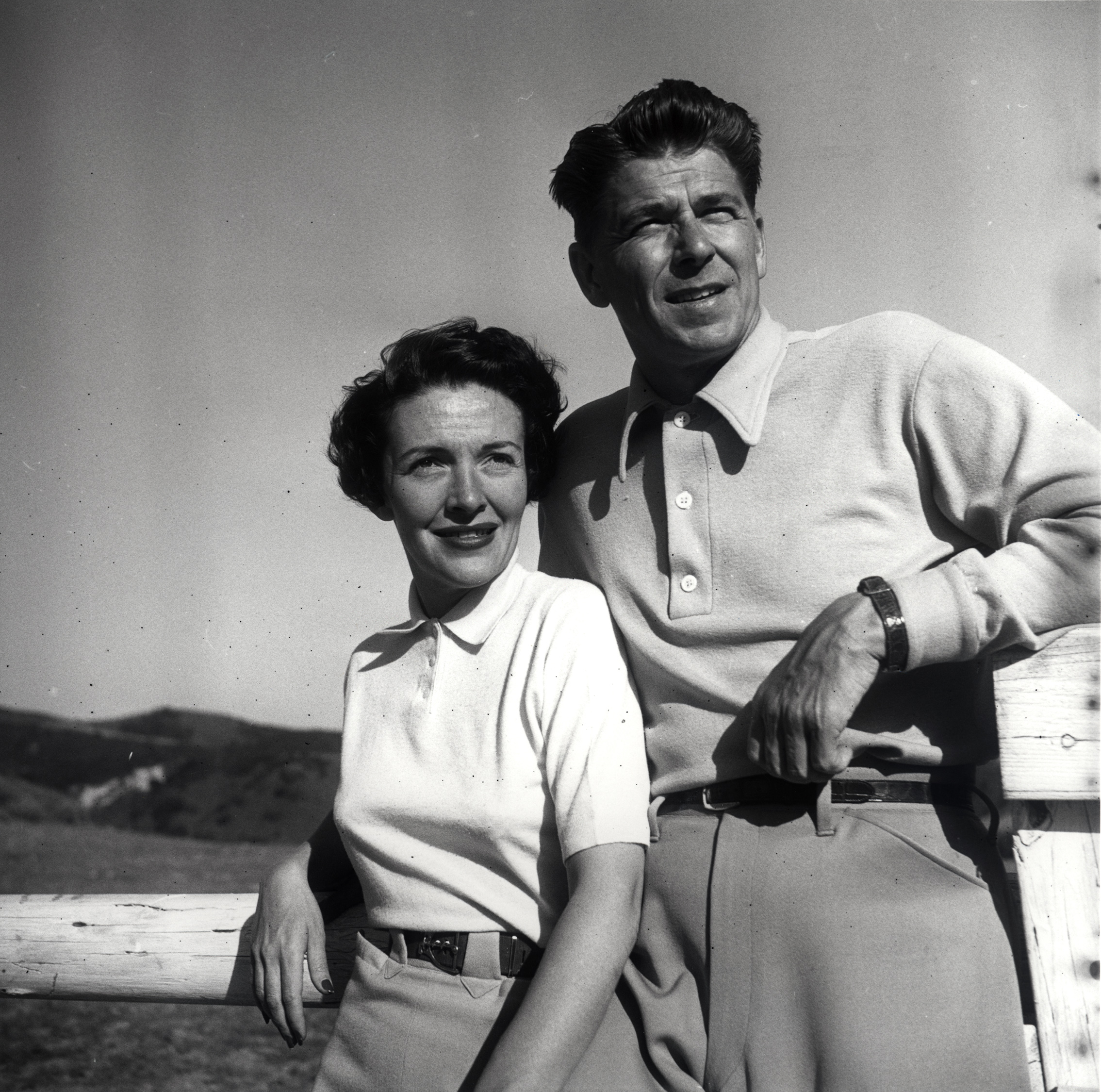 Ronald Reagan and Nancy Reagan posing leaning against a fence